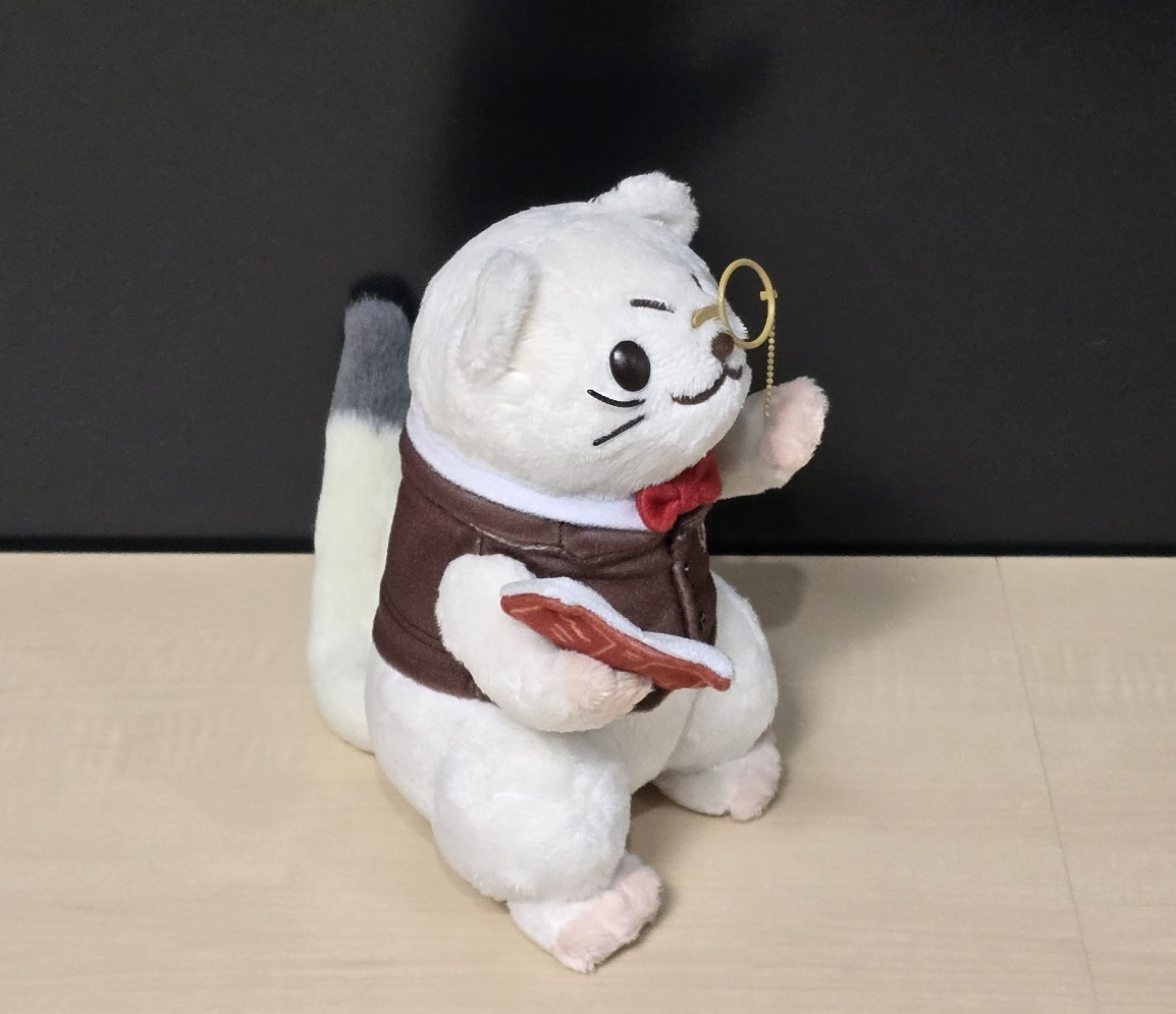 本と片眼鏡を持つログ男ぬいぐるみの横姿